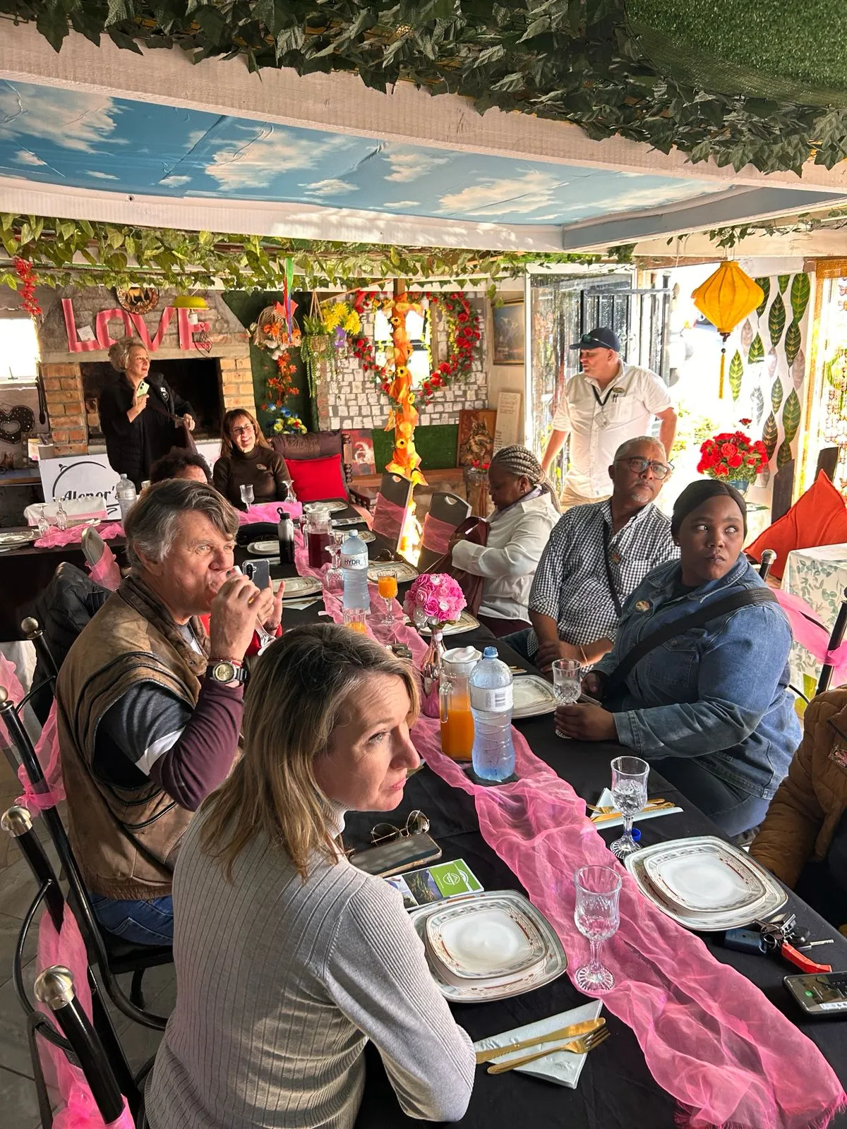 Guests gathered around a decorated table at Alenor's home in Pniel for a traditional potjiekos lunch