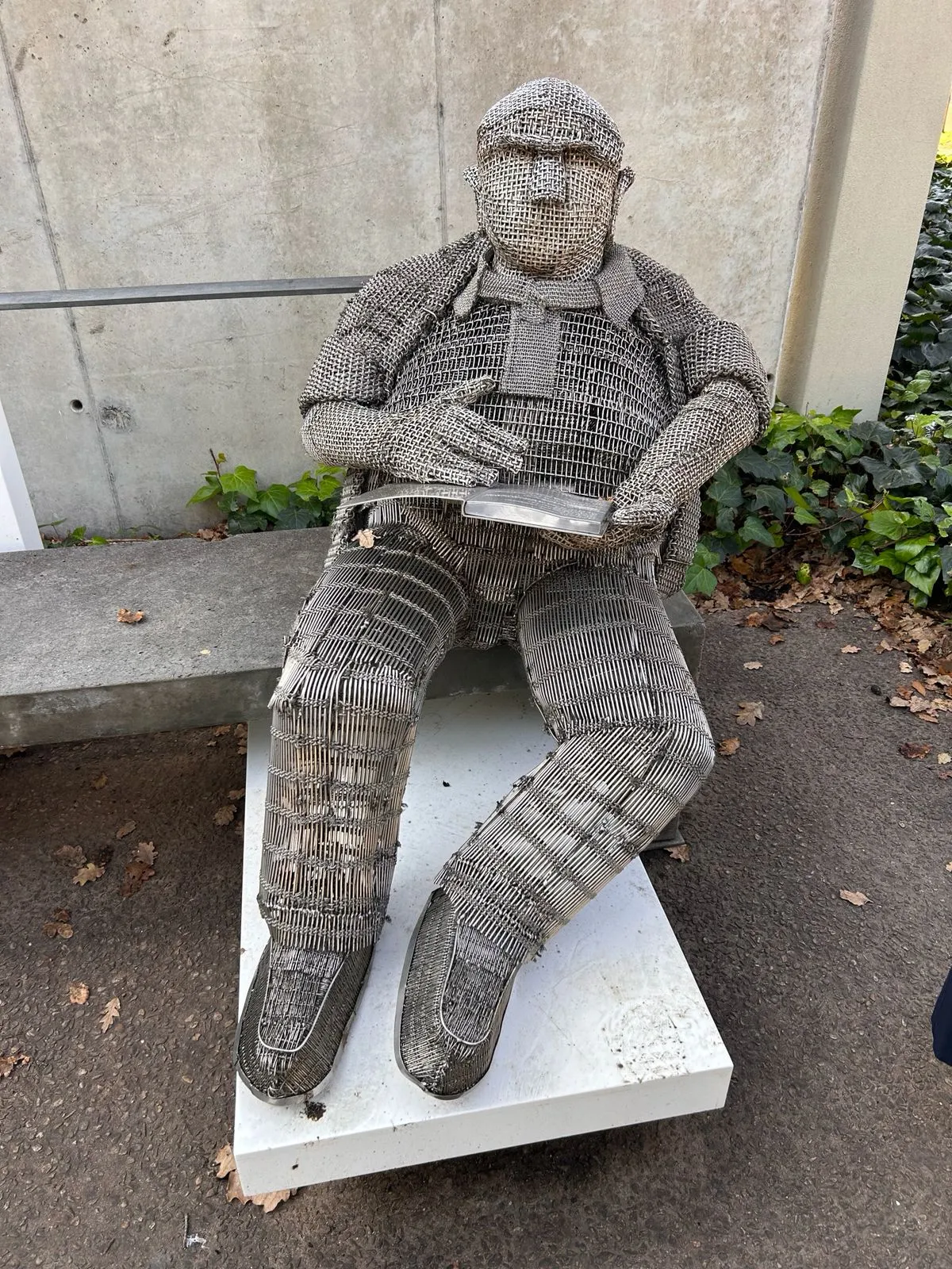 A life-size wire mesh sculpture of a seated man reading, part of the Art Mile along the Eerste Rivier