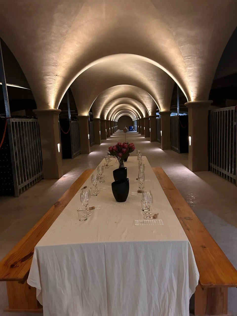 The vaulted barrel cellar at one of Robertson's estates, set with a long tasting table and proteas